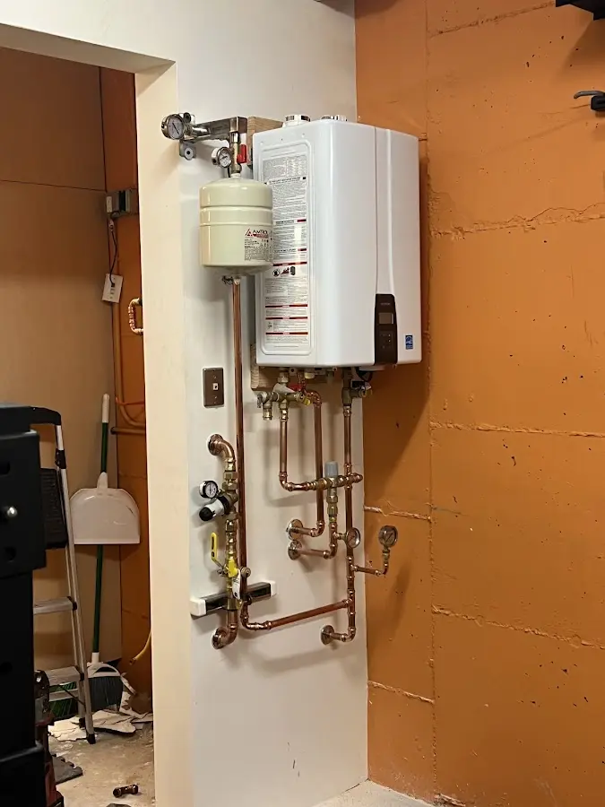 Plumbing technician inspecting water heater connections in Round Lake Beach